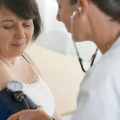 Lekarz mierzy ciśnienie pacjentce, która martwi się o uroner skutki uboczne.
