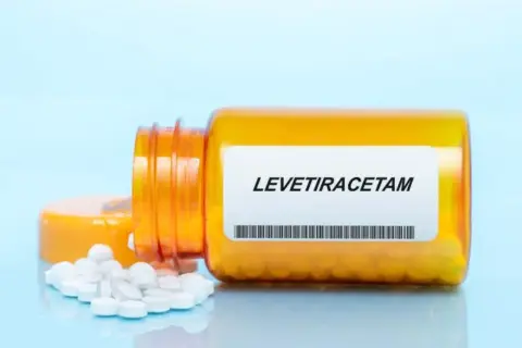 Butelka z lekiem levetiracetam, z której wysypały się tabletki. Warto pamiętać o levetiracetam skutki uboczne.