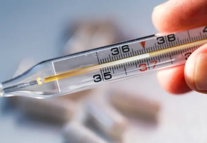 Zbliżenie na termometr rtęciowy, pokazujący skalę od 35 do 40 stopni Celsjusza. Wskazanie na termometrze to ok. 37.2°C. Pytanie: jak długo mierzyć temperaturę termometrem rtęciowym?
