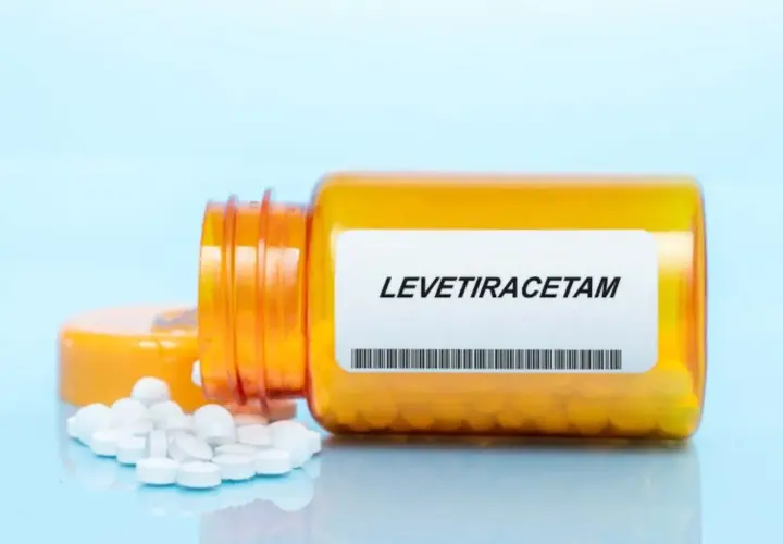 Butelka z lekiem levetiracetam, z której wysypały się tabletki. Warto pamiętać o levetiracetam skutki uboczne.