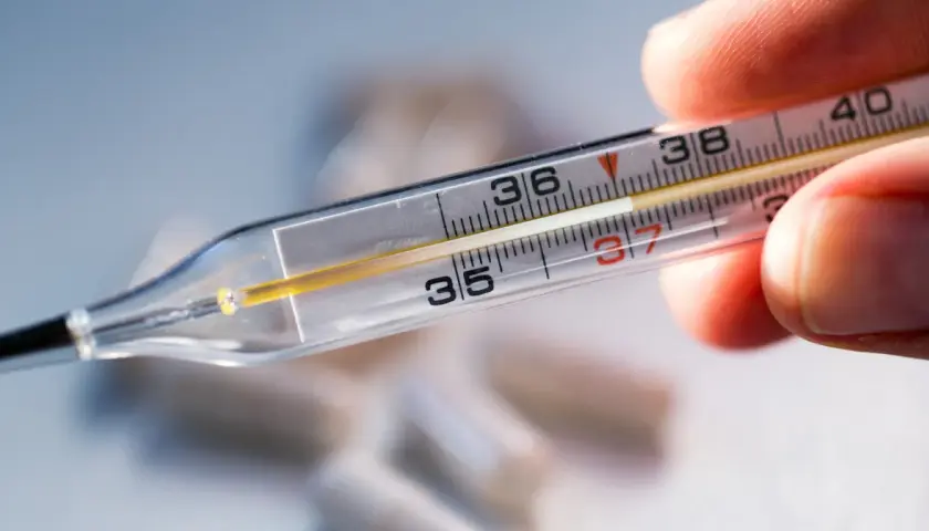 Zbliżenie na termometr rtęciowy, pokazujący skalę od 35 do 40 stopni Celsjusza. Wskazanie na termometrze to ok. 37.2°C. Pytanie: jak długo mierzyć temperaturę termometrem rtęciowym?