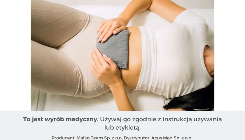 Kobieta z ulgą przykłada termofor na bol zoladka. Ciepło przynosi ukojenie.