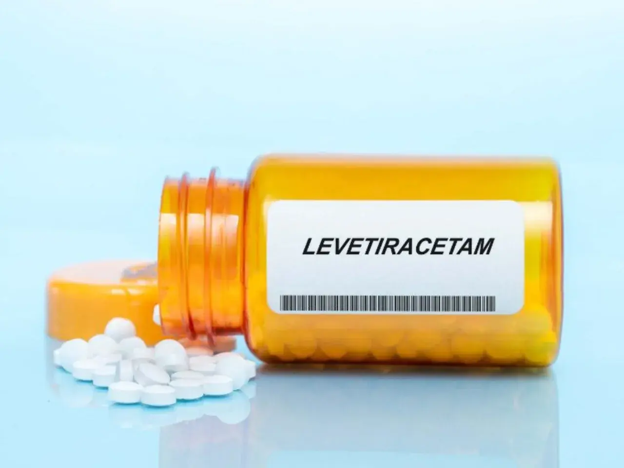 Butelka z lekiem levetiracetam, z której wysypały się tabletki. Warto pamiętać o levetiracetam skutki uboczne.